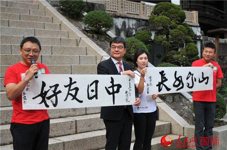 東京中國(guó)文化中心主任羅玉泉展示其為本次活動(dòng)書(shū)寫的題詞“中日友好，山高水長(zhǎng)”。人民網(wǎng) 蔣曉辰攝