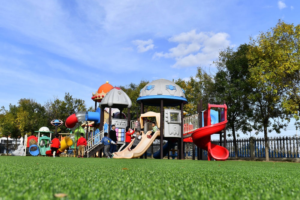在山東省東營市墾利區(qū)楊廟社區(qū)幼兒園，孩子們在老師的帶領(lǐng)下進(jìn)行戶外活動（2021年10月19日攝）。新華社記者 郭緒雷 攝