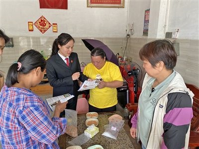  圖⑤：龍圩區(qū)法院法官到群眾家中開展法治宣傳。資料圖片