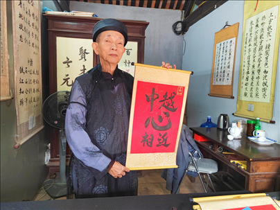 越南首都河內(nèi)文廟內(nèi)，阮明珠展示“中越心相近”書法作品。