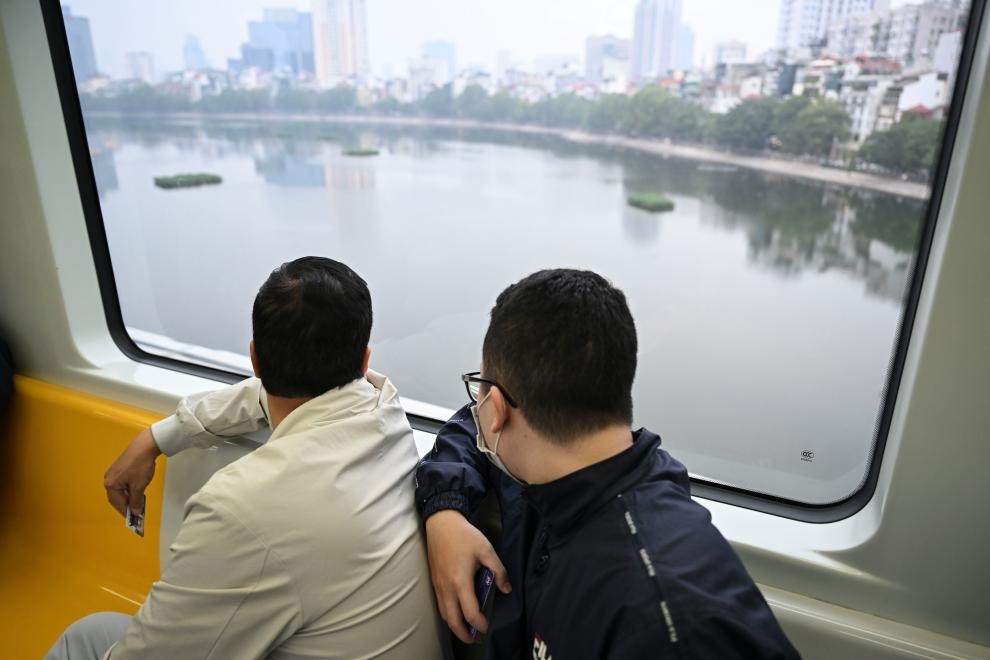 12月9日，市民在越南河內(nèi)輕軌二號線車廂內(nèi)透過車窗欣賞城市風(fēng)景。