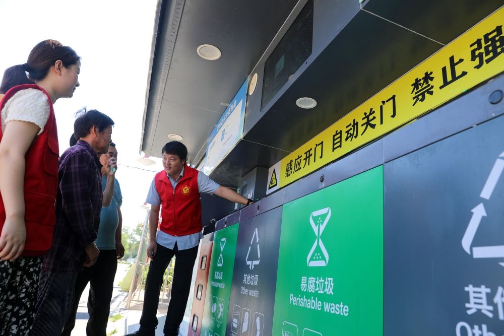 在安徽省合肥市長(zhǎng)豐縣莊墓鎮(zhèn)棗林社區(qū)，志愿者指導(dǎo)居民使用智能垃圾分類回收設(shè)備（2023年9月1日攝）。新華社記者 曹力 攝