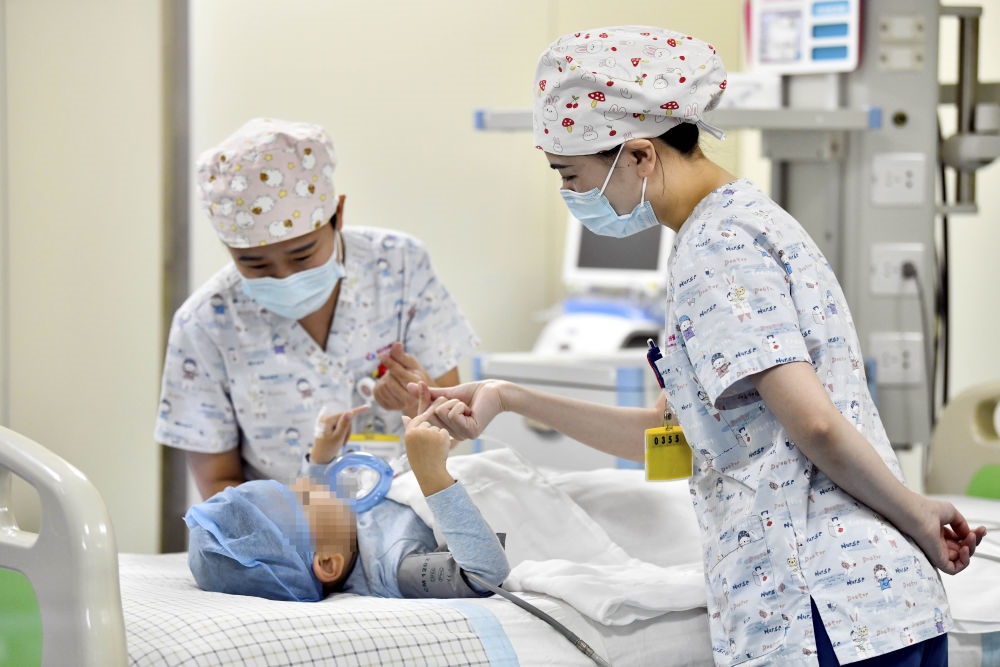 在山東省棗莊市婦幼保健院兒童ICU病房，醫(yī)護(hù)人員為完成靶向治療藥物諾西那生鈉的4歲脊髓性肌萎縮癥患兒加油鼓勁（2022年1月1日攝）。諾西那生鈉注射液是我國(guó)首個(gè)獲批治療脊髓性肌萎縮癥的進(jìn)口藥物，2019年進(jìn)入中國(guó)市場(chǎng)時(shí)，每針價(jià)格近70萬(wàn)元。在2021年國(guó)家醫(yī)保目錄藥品談判中，以3.3萬(wàn)元每針的價(jià)格進(jìn)入新版醫(yī)保藥品目錄。新華社記者 郭緒雷 攝