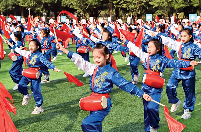 為助推民族地區(qū)基礎(chǔ)教育事業(yè)發(fā)展，廣西重新核定各地中小學(xué)教職工編制，依托全區(qū)編制“周轉(zhuǎn)池”核增事業(yè)編制給各地中小學(xué)，在全面達(dá)到國家標(biāo)準(zhǔn)的基礎(chǔ)上，進(jìn)一步統(tǒng)籌優(yōu)化和動態(tài)調(diào)整各區(qū)域、學(xué)校、學(xué)段間編制資源。圖為2023年11月29日，南寧市濱湖路小學(xué)舉行主題為“逐夢新時(shí)代 健體向未來”的體育文化節(jié)，孩子們正在跳腰鼓舞。 新華社記者 周華/攝