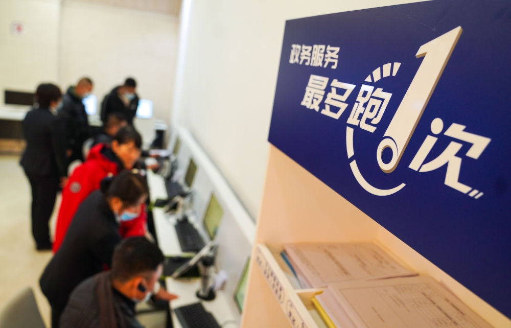 在吉林省長(zhǎng)春市二道區(qū)政務(wù)服務(wù)中心輔助填報(bào)區(qū)，市民在工作人員的輔助下進(jìn)行事項(xiàng)填報(bào)（2020年11月23日攝）。新華社記者 許暢 攝