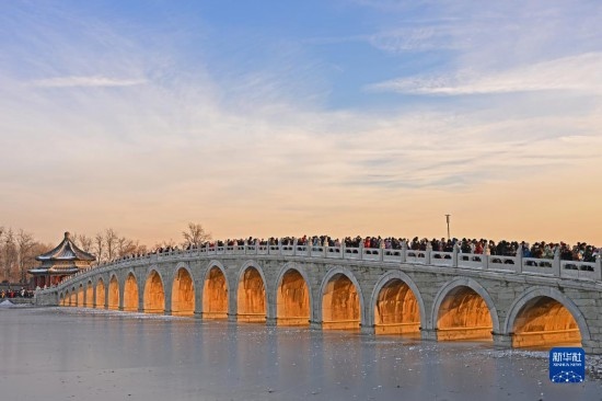 這是12月22日拍攝的頤和園十七孔橋“金光穿洞”景象。