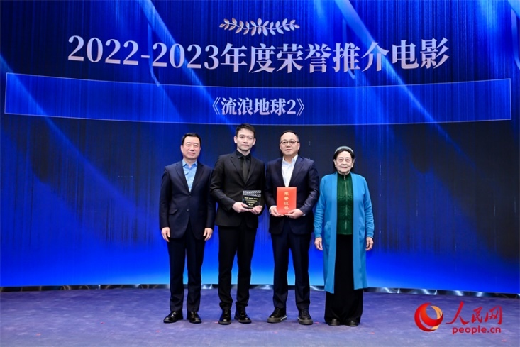 著名電影藝術(shù)家、事業(yè)家王曉棠（右一）和中國文聯(lián)書記處書記張宏（左一）為《流浪地球2》出品人、總監(jiān)制、總制片人傅若清（右二）與導(dǎo)演郭帆（左二）頒發(fā)“2022-2023年度榮譽推介電影”