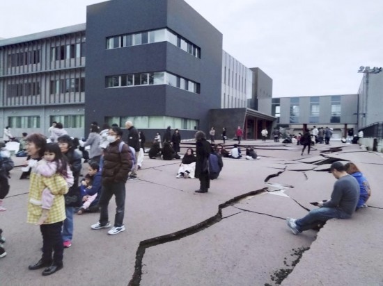 1月1日，在日本石川縣輪島市，人們站在被地震破壞的地面上。新華社/共同社