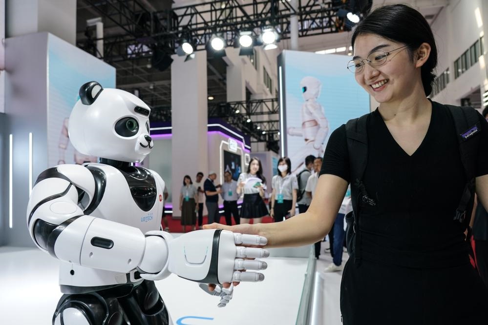 2023年8月16日，一名女士在北京舉辦的2023世界機(jī)器人大會(huì)現(xiàn)場(chǎng)與智能機(jī)器人握手。新華社記者彭子洋攝