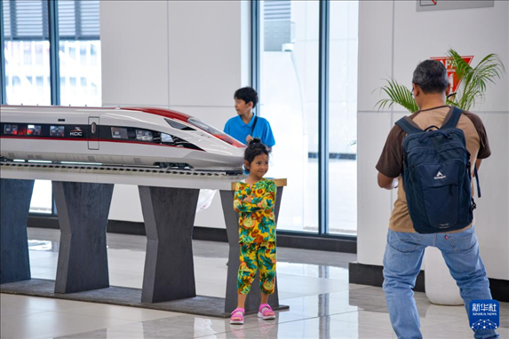 1月24日，在印度尼西亞雅加達(dá)哈利姆站候車大廳，一名小朋友和雅萬高鐵高速動(dòng)車組模型合影。新華社記者 徐欽 攝