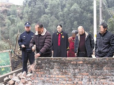  圖③：庭審結(jié)束后，在法官的見證下，陳某在院壩邊重新開鑿一條通道。