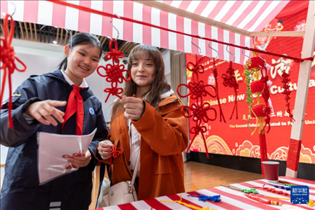 1月28日，復(fù)旦大學(xué)第二附屬學(xué)校學(xué)生（左）為美國(guó)馬斯卡廷中學(xué)學(xué)生（右）介紹中國(guó)結(jié)。 新華社記者 王翔 攝