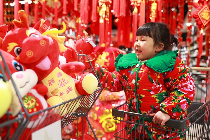 1月23日，在貴州省黔東南苗族侗族自治州岑鞏縣一家超市，小朋友在家人的帶領(lǐng)下選購龍年毛絨玩具。新華社發(fā)（唐鵬攝）