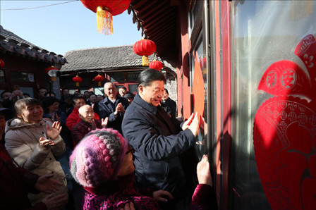 2019年2月1日上午，習近平總書記在前門東區(qū)草廠四條胡同32號院，高興地拿起一幅“?！弊郑H自貼到門上，給這里的老街坊們拜年。新華社記者鞠鵬攝