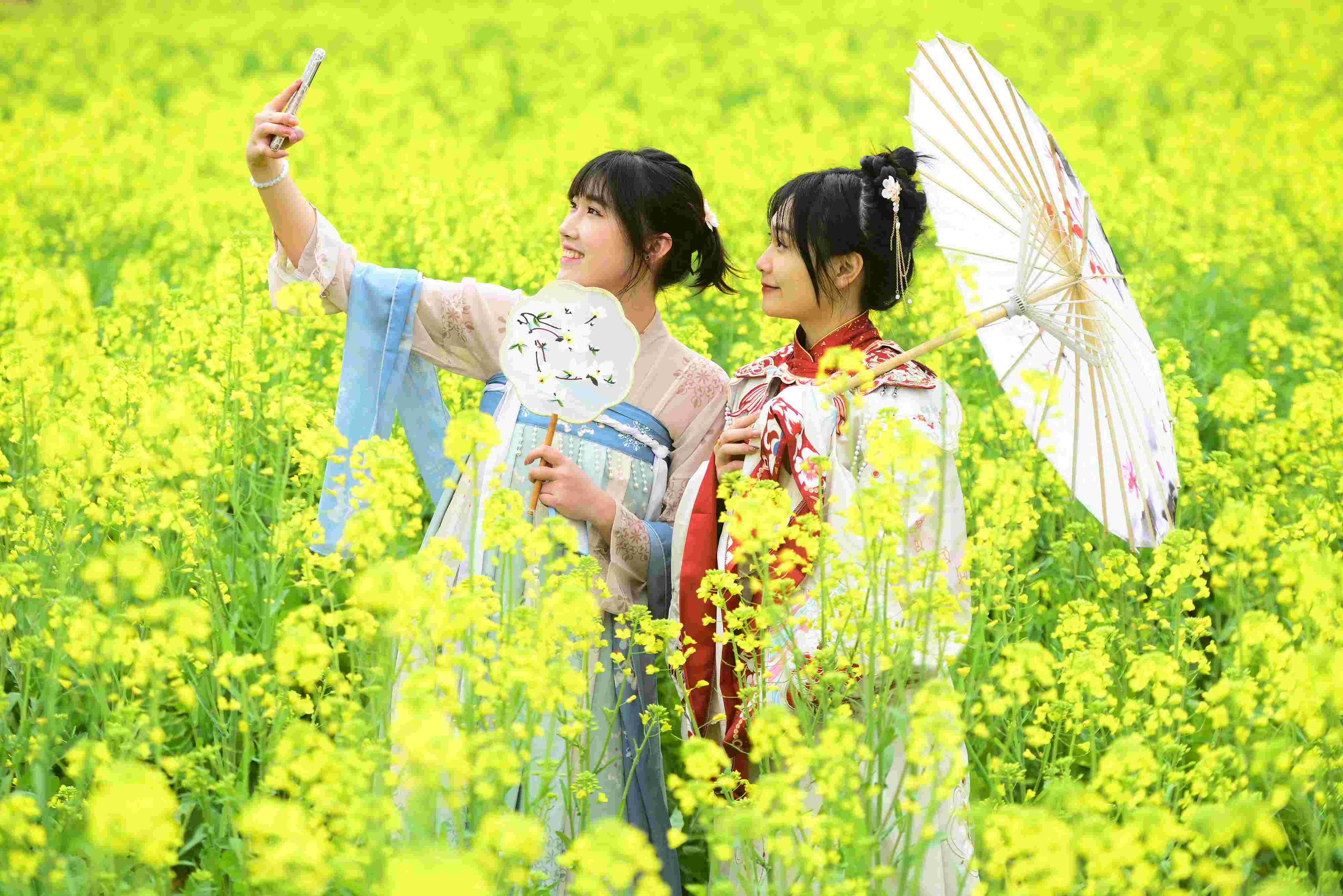 △ 2024年2月16日，廣西賀州，在富川瑤族自治縣麥嶺鎮(zhèn)三民村，游客在油菜花田間賞花拍照。