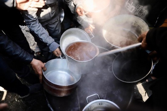  2月27日，在加沙地帶北部的杰巴利耶難民營(yíng)，人們領(lǐng)取食物。新華社發(fā)（穆罕默德·阿里攝）