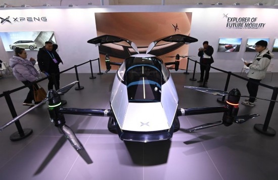 2023年12月1日，在鏈博會智能汽車鏈展區(qū)小鵬汽車展臺，參觀者觀看一臺智能飛行器。新華社記者蔡湘鑫攝