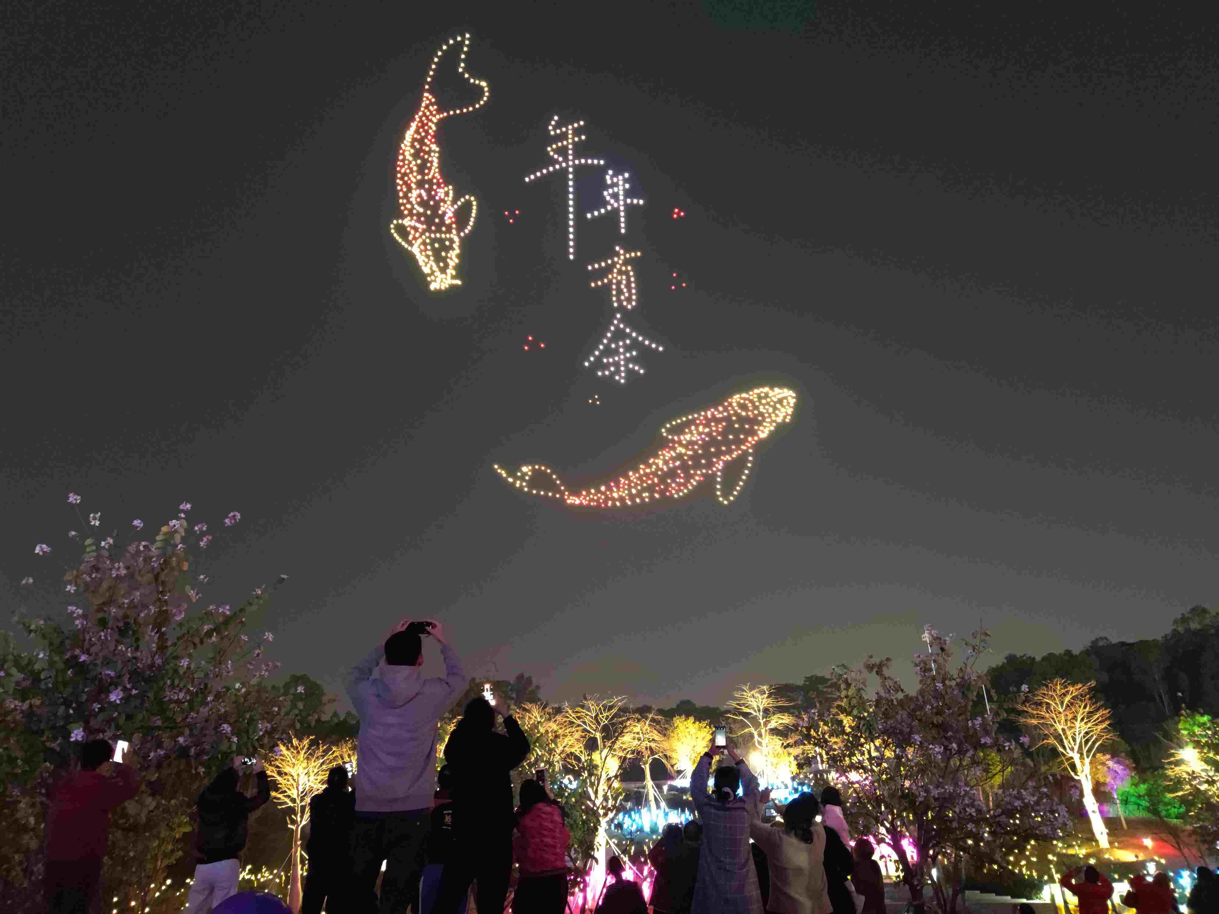 △ 2024年2月10日，深圳北站中心公園，春節(jié)主題無人機(jī)燈光秀引來眾多游客駐足觀看。