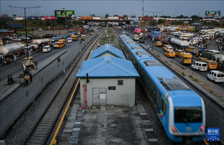 3月4日，在尼日利亞拉各斯，一列輕軌藍線列車行駛至公路交通擁堵路段附近。新華社記者 韓旭 攝