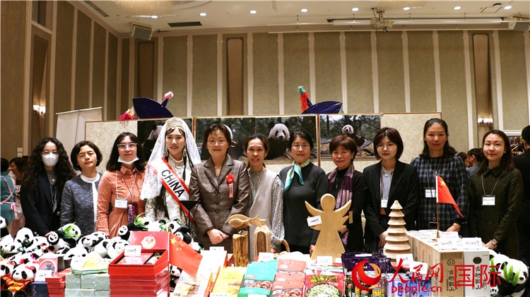 中國駐日本大使吳江浩夫人丁玥（左五）與使館人員在展位前合影留念。人民網(wǎng) 許可攝