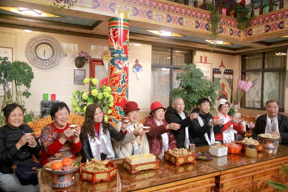 游客們?nèi)胱∶袼藓?，舉杯共飲酥油茶。新華社記者 邱星翔 攝