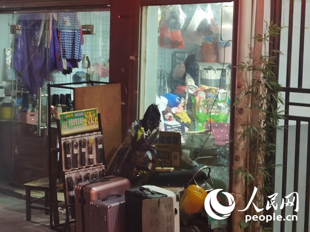 南寧“城中村”一裁縫鋪老板將電線從店內(nèi)拉出為電動自行車充電。人民網(wǎng) 覃心攝