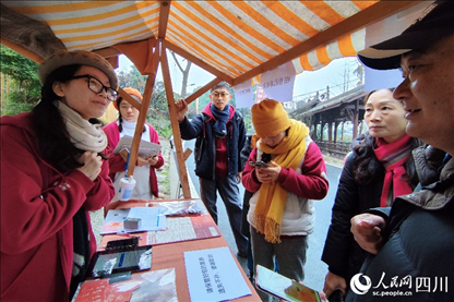 1月6日，“2024成都蒲江柑甜采摘節(jié)”上，記者見到了小萌（左一）和許多年輕人忙著做訪客接待、現(xiàn)場布置、票務(wù)核對、采摘服務(wù)等工作。人民網(wǎng)記者朱虹攝