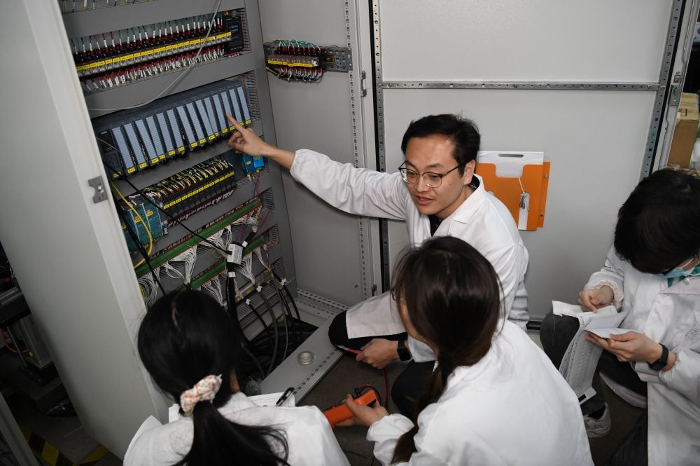 2024年4月6日，在位于安徽合肥的中國(guó)科學(xué)技術(shù)大學(xué)，安徽省先進(jìn)功能高分子薄膜工程實(shí)驗(yàn)室團(tuán)隊(duì)成員在檢修自主研制的高分子薄膜原位雙向拉伸實(shí)驗(yàn)設(shè)備的電氣控制系統(tǒng)。