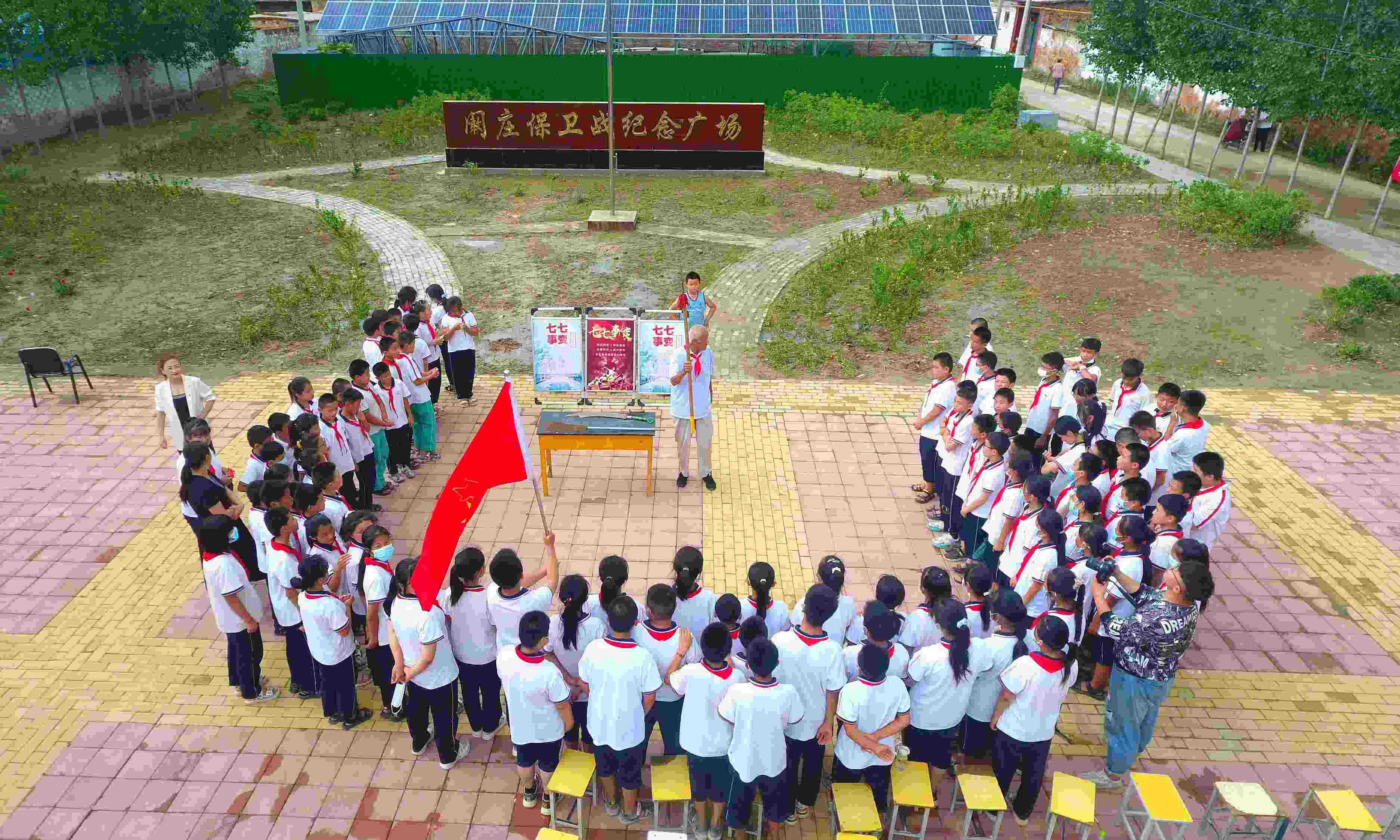 2022年7月6日，山東省聊城市，在茌平區(qū)菜屯鎮(zhèn)闞莊村的闞莊保衛(wèi)戰(zhàn)紀(jì)念廣場(chǎng)，闞莊保衛(wèi)戰(zhàn)親歷者王光木老人為小學(xué)生們講述抗戰(zhàn)故事，展示大刀、長(zhǎng)矛。