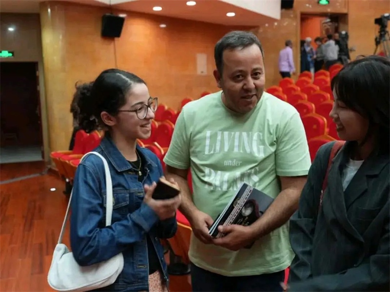 阿爾及利亞市民拉納·艾薩尼和她父親現(xiàn)場聆聽中阿交響樂演出 。蘇州交響樂團供圖
