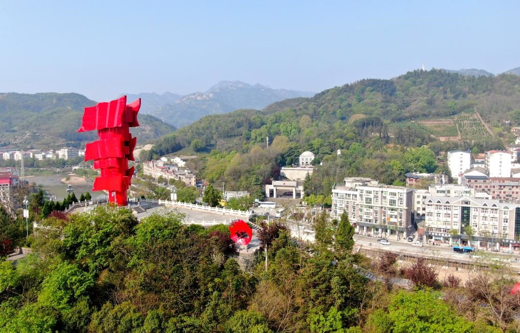 這是2021年4月9日拍攝的鄂豫皖蘇區(qū)首府革命博物館附近的英雄山上的“紅旗飄飄”主題雕塑（無(wú)人機(jī)照片）。新華社發(fā)