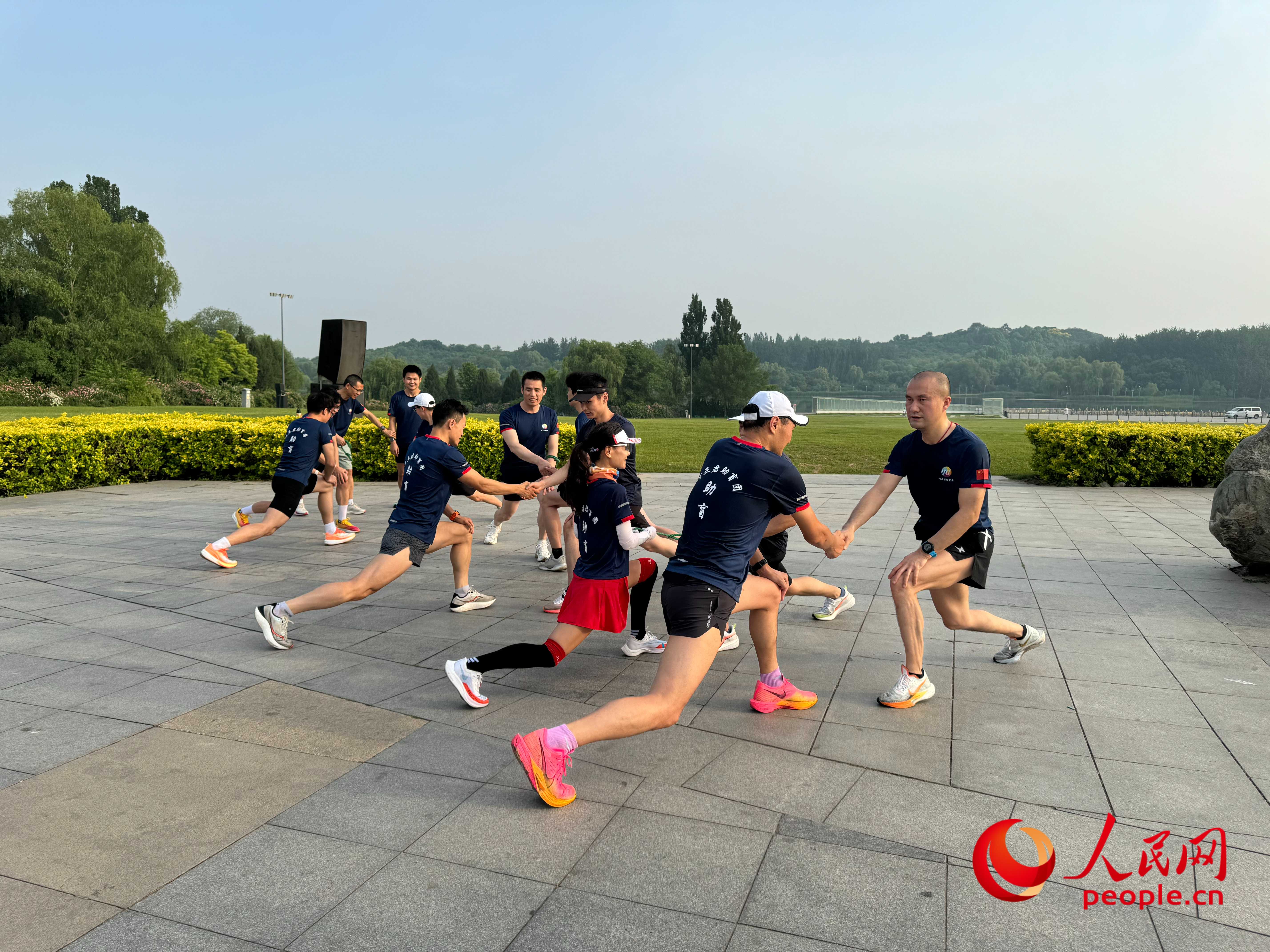 盲人和志愿者做跑步前準(zhǔn)備。人民網(wǎng) 周靜圓攝