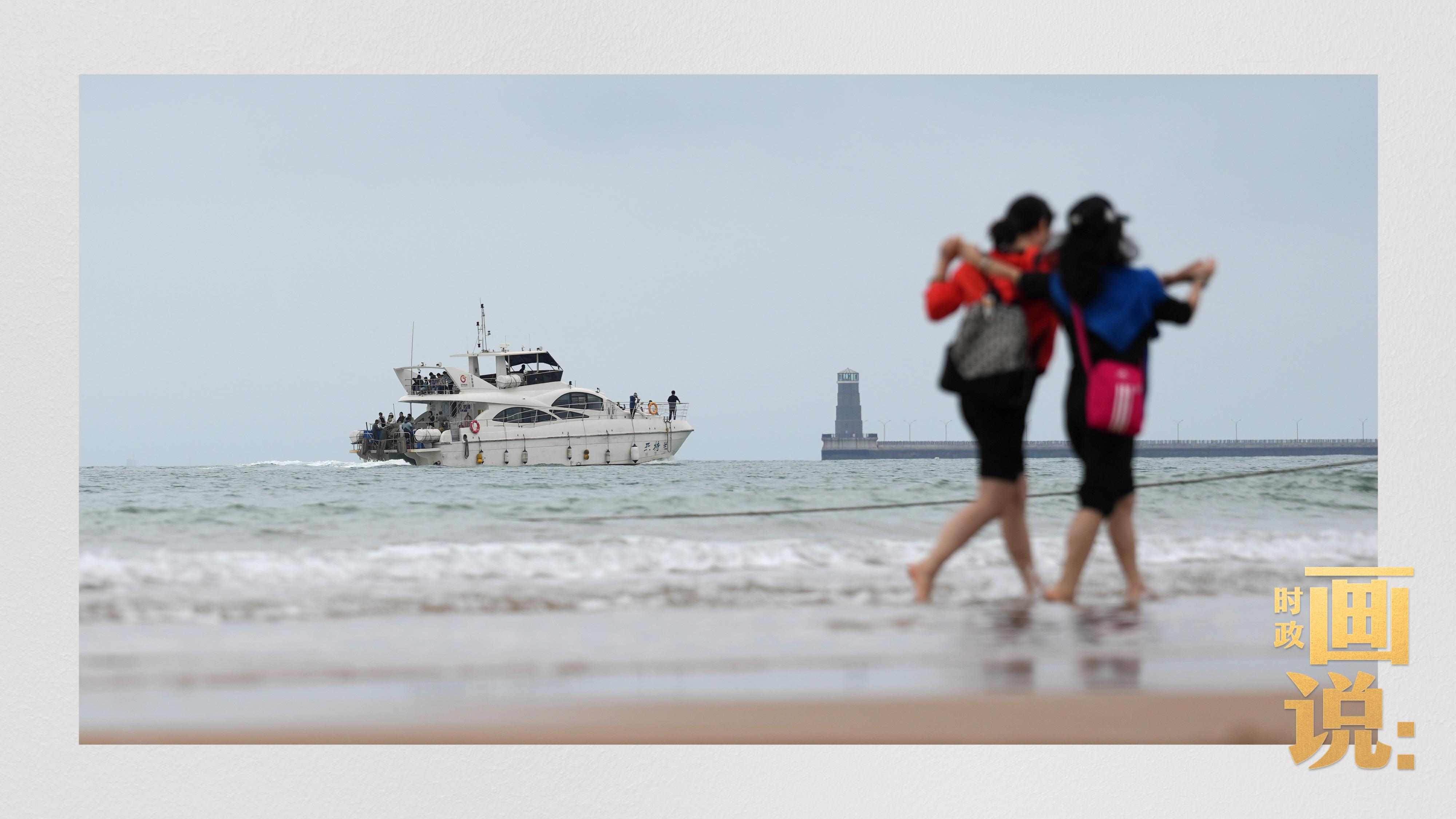 △日照陽光海岸綠道上的萬平口景區(qū)，一對游客在海浪中翩然起舞。