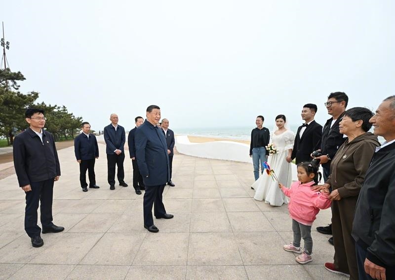 5月22日，在山東日照考察調(diào)研的習(xí)近平總書記來(lái)到陽(yáng)光海岸綠道，同市民游客親切交流。