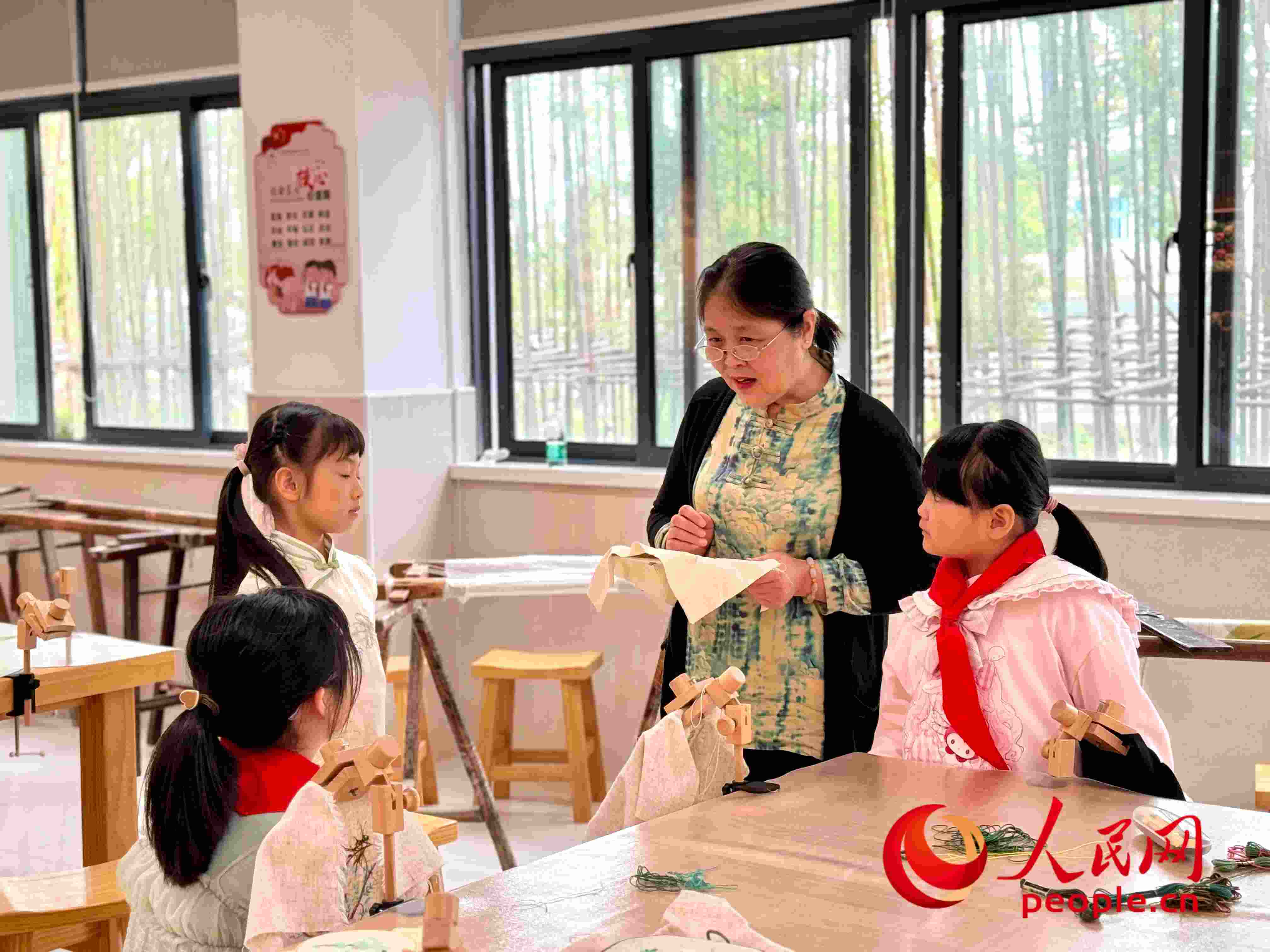 顧建珍（左三）在教孩子們刺繡知識(shí)。人民網(wǎng) 周靜圓攝