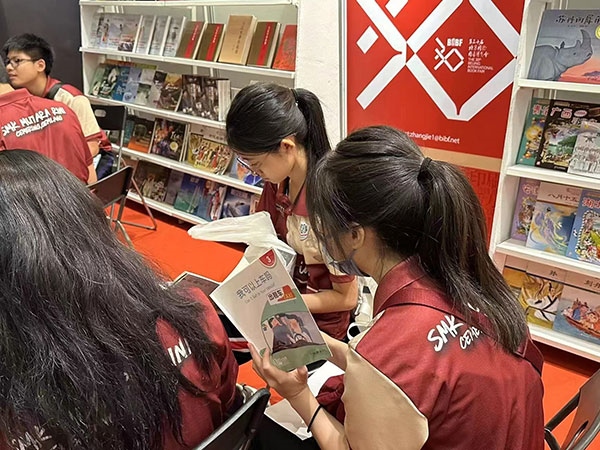 馬來西亞讀者在中國聯(lián)合展臺翻閱中國書籍。 中國圖書進出口（集團）有限公司供圖
