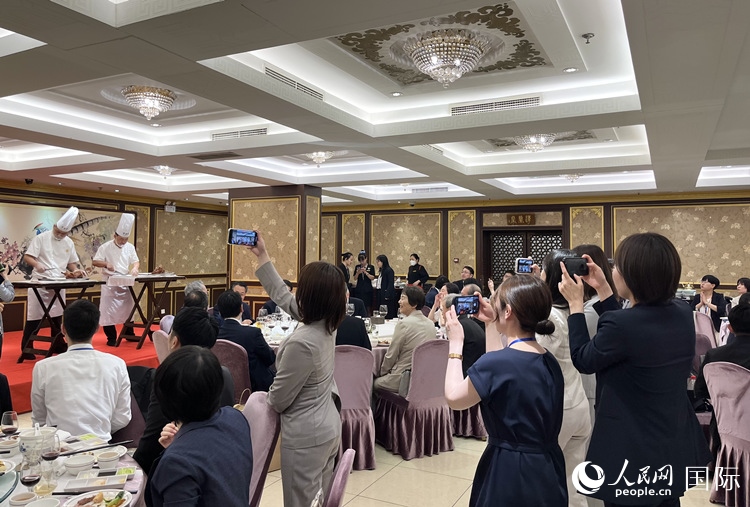 國家級非物質(zhì)文化遺產(chǎn)、全聚德片鴨工藝吸引代表團(tuán)成員拍照留念。