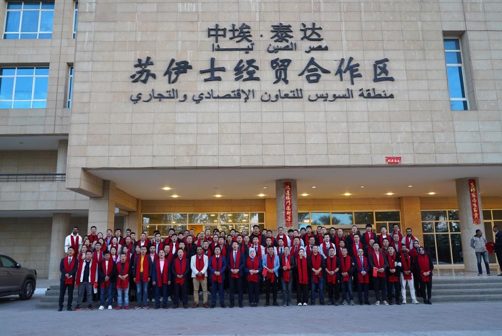 2024年2月11日，在位于埃及蘇伊士省的中?！ぬ┻_(dá)蘇伊士經(jīng)貿(mào)合作區(qū)，中埃員工在合作區(qū)辦公大樓前合影拜年。新華社發(fā)（泰達(dá)合作區(qū)供圖）