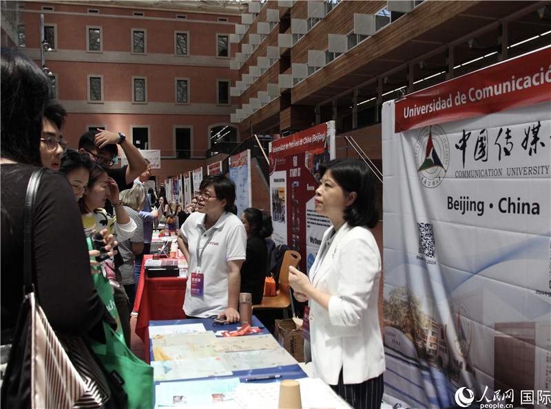 旅西華人華僑在展臺(tái)前咨詢。人民網(wǎng)記者 許海林?jǐn)z