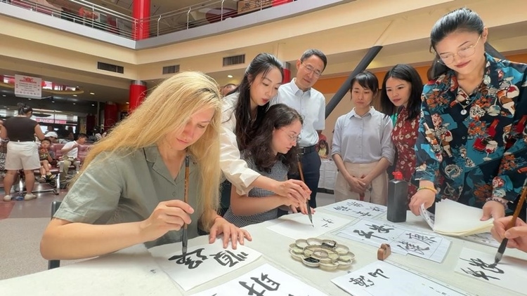 羅馬尼亞友人在活動現(xiàn)場學(xué)寫漢字。中國駐羅馬尼亞大使館領(lǐng)僑處供圖
