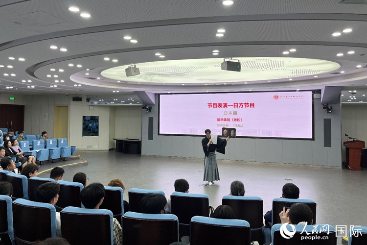 日本大學(xué)生介紹能樂(lè)知識(shí)。人民網(wǎng)記者 陳思攝