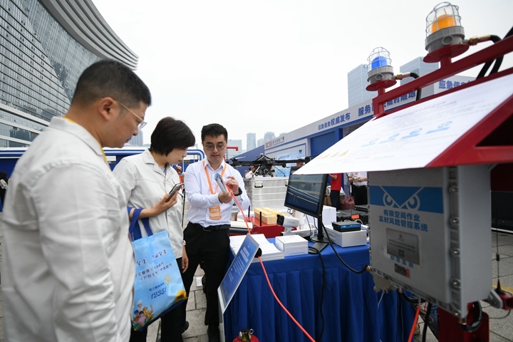 6月16日，在全國“安全宣傳咨詢?nèi)铡敝鲌龌顒?dòng)上，四川省安全科學(xué)技術(shù)研究院工作人員（右一）向參觀者介紹“有限空間作業(yè)實(shí)時(shí)風(fēng)險(xiǎn)管控系統(tǒng)”。新華社記者胥冰潔攝