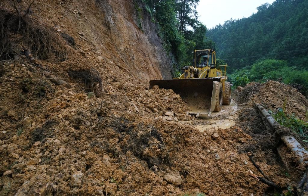 6月18日，在廣西融水苗族自治縣融水鎮(zhèn)新安村，一臺推土機在清理塌方路段。新華社發(fā)（龍林智攝）