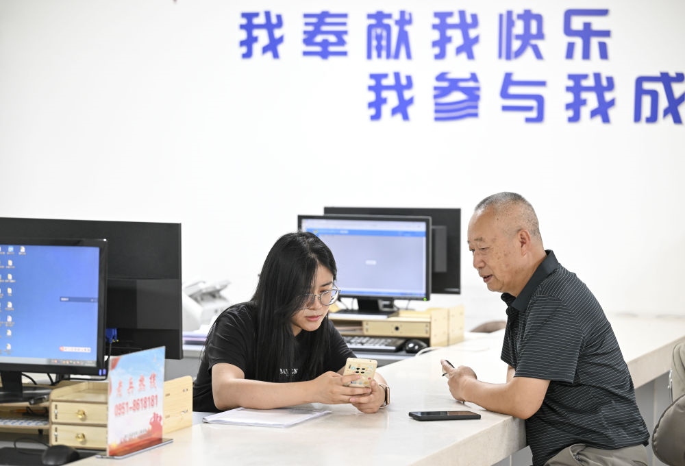 6月20日，在長(zhǎng)城花園社區(qū)黨群服務(wù)中心，工作人員幫助居民辦理業(yè)務(wù)。