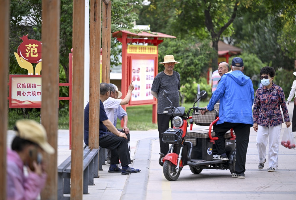 6月20日，長(zhǎng)城花園社區(qū)的居民在休閑、聊天。