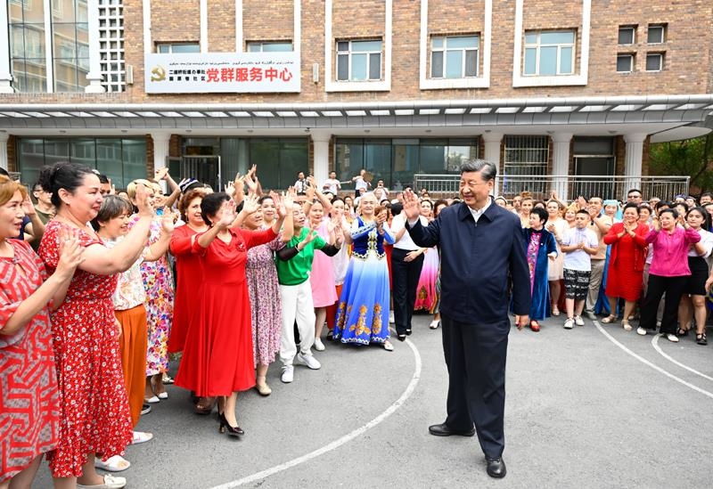 2022年7月13日，習(xí)近平總書記在新疆烏魯木齊市天山區(qū)固原巷社區(qū)考察時(shí)，向各族群眾揮手致意。