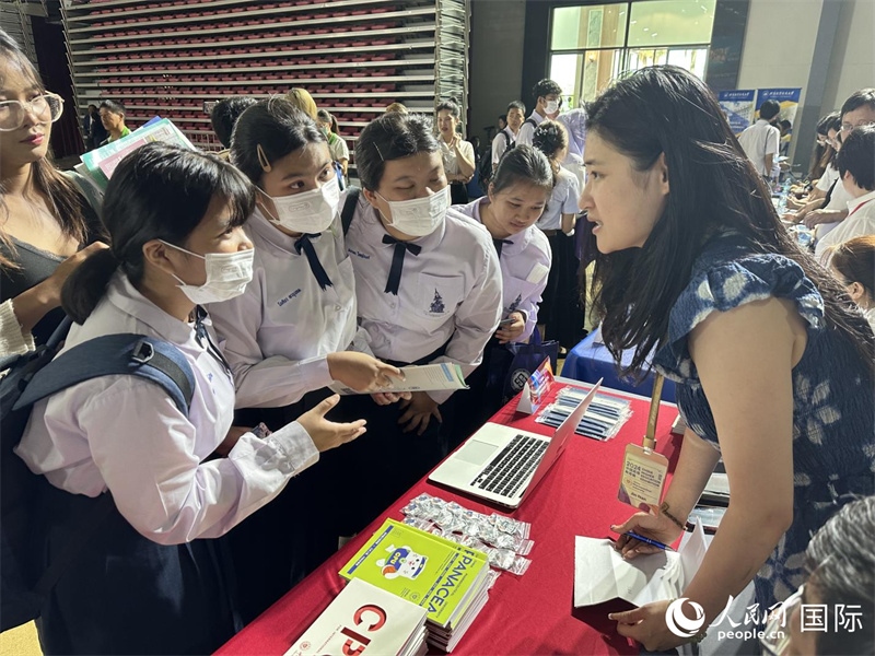 來自泰國的學生、家長在教育展臺前咨詢。人民網(wǎng)記者 簡承淵攝