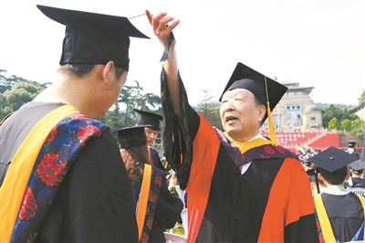 2017年6月22日，李德仁（右一）參加武漢大學(xué)畢業(yè)典禮并為畢業(yè)生撥穗。