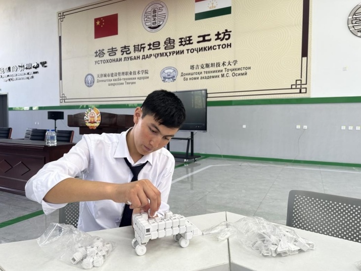 在塔吉克斯坦魯班工坊內(nèi)，學員正在操作能力源創(chuàng)新套件。本報記者 屈佩 攝