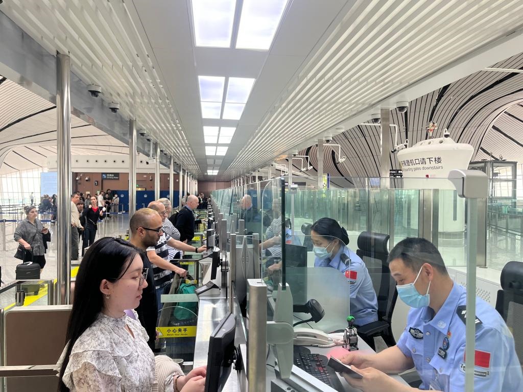 7月5日，北京大興國(guó)際機(jī)場(chǎng)邊檢站民警正在辦理邊檢查驗(yàn)手續(xù)。（北京大興國(guó)際機(jī)場(chǎng)邊檢站供圖）